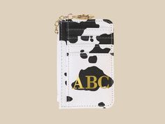 a black and white phone case with an abc logo on the front, hanging from a gold chain