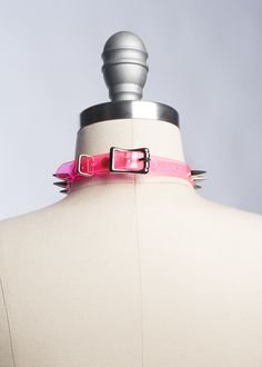 Classic choker collar with a colorful twist. Silver 1/2" spikes riveted evenly throughout. Adjustable buckle in back. Available in PVC, leather, or vegan leather. An essential item for any goth or punk who likes a little bit of color, festival or clubkids-inspired looks. Collar is 1/2" wide. Shown in neon pink PVC. Silver-toned nickle plated steel hardware. Neon pink and neon orange PVC are UV/Blacklight reactive. SMALL/MEDIUM (11-13")MEDIUM/LARGE (13-15")LARGE/X-LARGE (15-17") Custom sizing ava Punk Choker With Spikes, Gothic Spiked Choker For Festivals, Adjustable Punk Choker For Alternative Fashion, Punk Spiked Choker For Parties, Punk Spikes Choker For Party, Edgy Adjustable Festival Choker, Adjustable Edgy Festival Choker, Edgy Adjustable Choker For Festival, Edgy Spiked Choker For Party