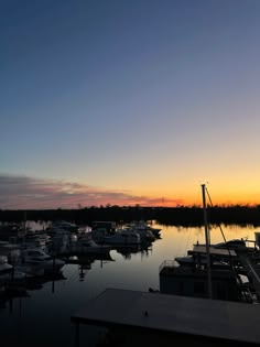 boats are docked in the water at sunset