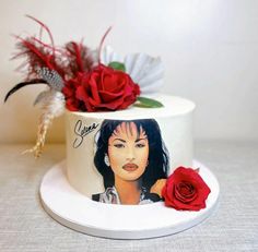 a white cake with red roses on top and an image of a woman's face