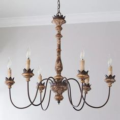 a chandelier with five candles hanging from it's center and four arms