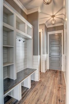 an empty room with white walls and wooden floors, built in shelving units on either side of the door