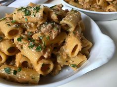 two white bowls filled with pasta and meat