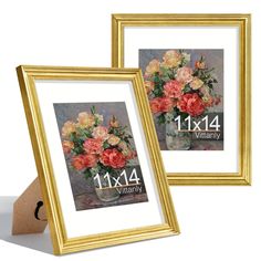 two framed pictures with flowers in them sitting on a table next to a brown paper bag