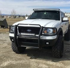 a white truck parked on top of a dirt field