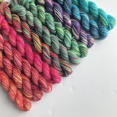 several skeins of multicolored yarn laid out on a white table top