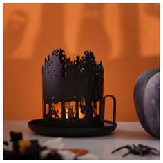 a candle that is sitting on a table next to some pumpkins and other halloween decorations