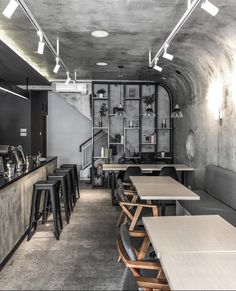 the interior of a restaurant with tables and stools