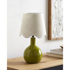 a green lamp sitting on top of a wooden table