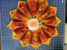 an overhead view of a quilted table with orange and yellow umbrellas on it