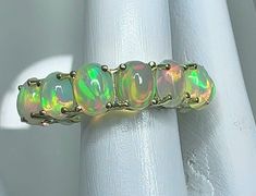 GREETINGS FROM H U PATEL GEMS . Today we have a Oval opal full eternity wedding gift for you These opals have nice play of colour, ethically sourced natural gemstone and all are 7#5mm.These 14 opals weigh 5.80 carat total. This band can be gifted by you to your mother on her anniversary. Natural opal 5.80 carat crafted in 14k white gold net weight of gold 3.240gram to make a beautiful Eternity Band Luxury Stackable Opal Ring, Luxury Stackable Opal Ring For Wedding, Eternity Rings Stackable, Full Eternity Ring, Ring Wedding Band, Stackable Ring, Eternity Band, Natural Sapphire, Natural Opal