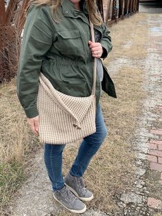 a woman standing on the side of a road holding an umbrella over her head and looking at the camera