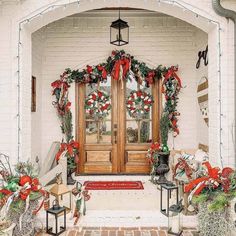 the front door is decorated for christmas with wreaths and garland on it's doors