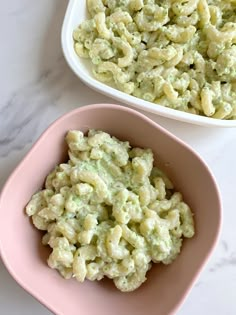 two bowls filled with macaroni salad on top of a table