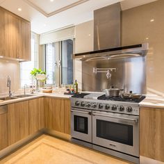 a modern kitchen with stainless steel appliances and wood cabinets