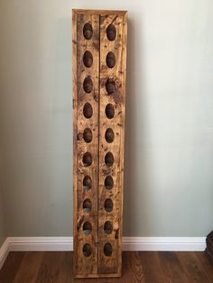 a tall wooden cabinet sitting on top of a hard wood floor next to a wall