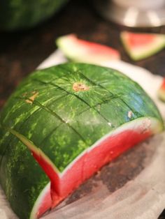 a piece of watermelon sitting on top of a white plate next to other pieces of fruit