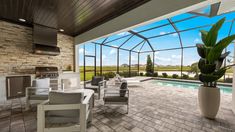 an outdoor kitchen and dining area with a pool in the back ground, surrounded by glass walls