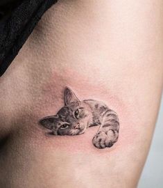 a small cat tattoo on the thigh