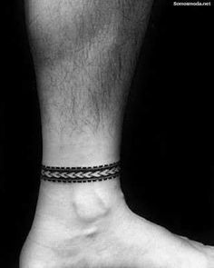 black and white photograph of a man's foot with a tattoo on his ankle