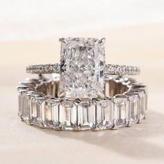 an engagement ring and wedding band set with a large diamond in the center, surrounded by baguettes