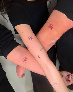 two people with matching tattoos on their arms