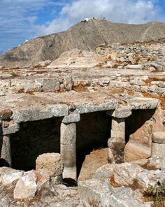 an ancient structure with rocks and boulders on the ground