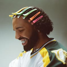 a man with long hair and colorful clips in his hair