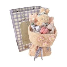 a teddy bear in a basket with other stuffed animals inside it next to a gift bag