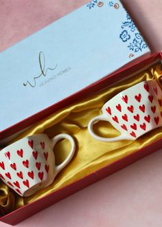 two coffee mugs in a gift box with hearts on them