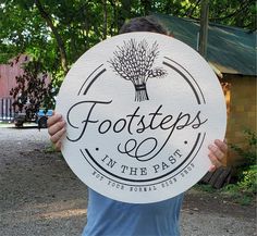 a man holding up a white sign that says foot steps in the past on it