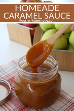 homemade caramel sauce in a glass jar with a wooden spoon and apples in the background