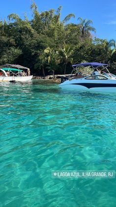 two boats floating on top of a body of water next to lush green jungles