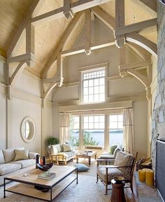 a living room filled with furniture and a fire place next to a stone wall covered in windows