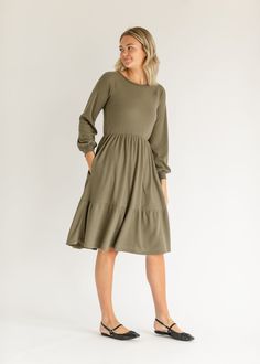 The Luna Long Sleeve Tiered Midi Dress is a waffle knit dress with a modest round neckline, and long sleeves. It is graced with a single tier that will flow throughout your day, wherever it may take you. This dress is fully lined providing it with extra warmth and a layer for modestly. Pair it will your favorite flats for a classic church or work look! Style | Midi, Long Sleeve Dress, Lined Color | Olive SIZING TIPS Fit | Semi-Fitted Stretch | Stretchy Model | True to Size Midi Long Sleeve Dress, Tiered Midi Dress, Work Looks, Dress Gift, Tops Fall, Clothing Company, Waffle Knit, Xl Dress, Skirt Top