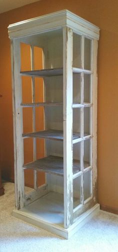 an old white bookcase in the corner of a room with orange walls and carpet