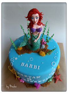 there is a cake with a little mermaid on it