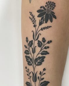 a black and white flower tattoo on the right leg, with small leaves in it