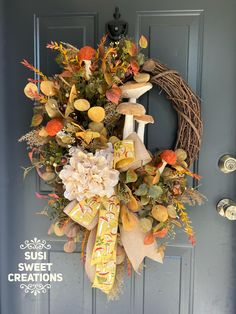 a wreath on the front door with autumn leaves and flowers hanging from it's side