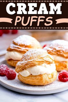 two cream puffs on a plate with raspberries