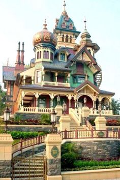 a large house with lots of windows and balconies on the top floor, surrounded by greenery