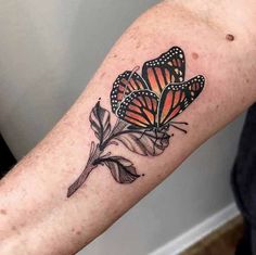 a close up of a person's arm with tattoos on it and two butterflies