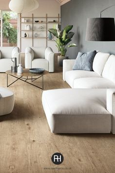 a living room filled with white furniture and lots of windows