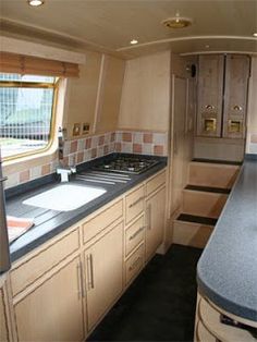 a kitchen area with sink, stove and refrigerator in a recreational vehicle or camper