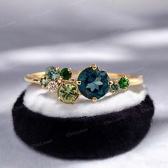 three different colored stones on top of a black ring