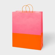 a pink and orange shopping bag on a white background with an orange string hanging from the handle