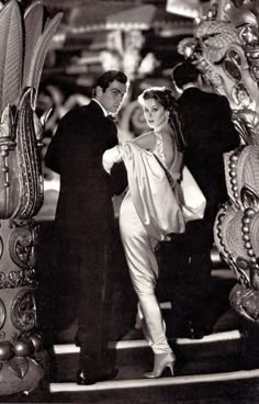 a man and woman standing next to each other in front of an elaborately designed sculpture