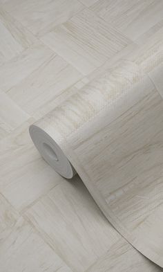 a roll of white paper sitting on top of a wooden floor