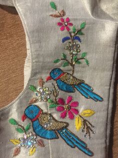 the back of a jacket with two birds on it and flowers in the middle of the vest