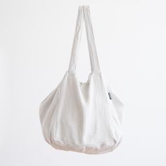 a white bag hanging from a hook on a wall